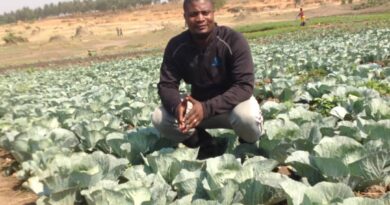 Marius Ziganira poses in his cabbage patch at the Nakivale Refugee Camp